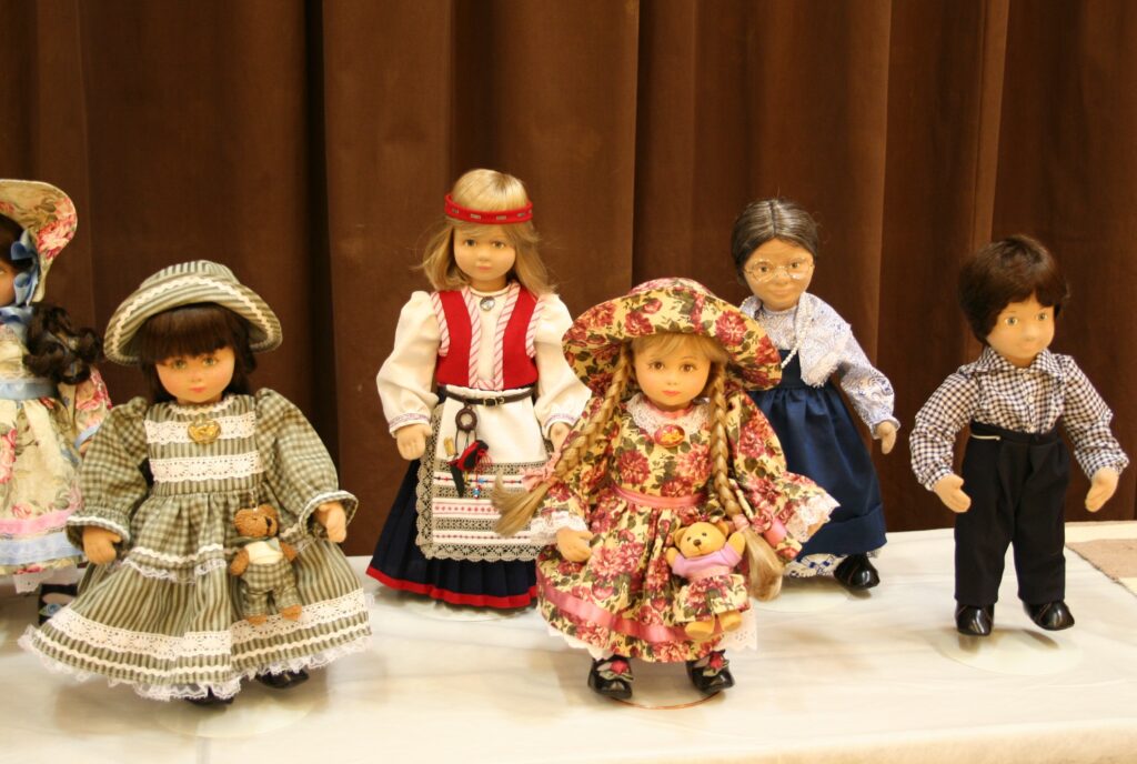 Kuvassa on kurssilla valmistettuja vanhantyylisiin asuihin puettuja nukkeja, Yhdellä nukella on kansallispuku.