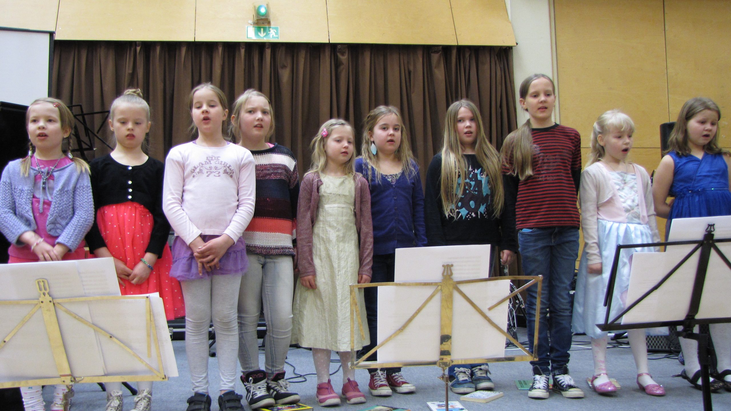Kymmenen alakouluikäistä tyttöä esittää kuorolaulua.