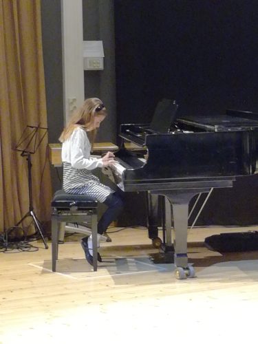 Tyttö soitamassa pianoa.