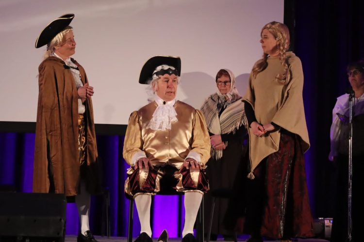 Naisia ja miehiä roolivaatteissa esiintymässä yleisölle.