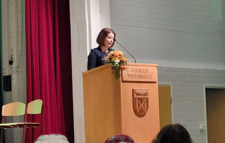 Nainen pitää juhlapuhetta puhujanpöntössä.